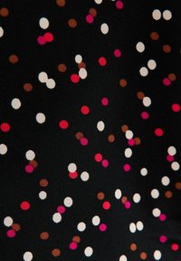 Schwarzer Stoff mit verschieden großen Punkten in Pink, Weiß und Braun, der ein verspieltes Muster mit glatter Textur bildet.