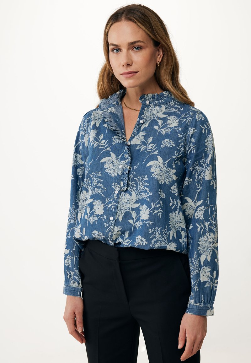 Modrá květinová košile na knoflíky s volánkovým límcem, vyrobená z jemné denimu a s dlouhými rukávy, spárovaná s černými kalhotami.