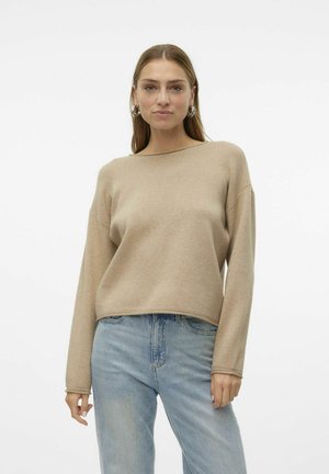 Maglione beige cropped con maniche lunghe, scollatura rotonda e una texture morbida. Abbinato a jeans in denim azzurro chiaro, design minimalista.