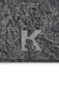 Χρυσή τσάντα clutch από τζιν σε σκούρο γκρι με υφή. Διαθέτει το μεταλλικό ασημί λογότυπο "K" που είναι prominently displayed.