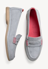 Grijze suède loafers met een roze interieur, voorzien van een low profile, platte zool, rode accentstiksels en een decoratieve band aan de voorkant.