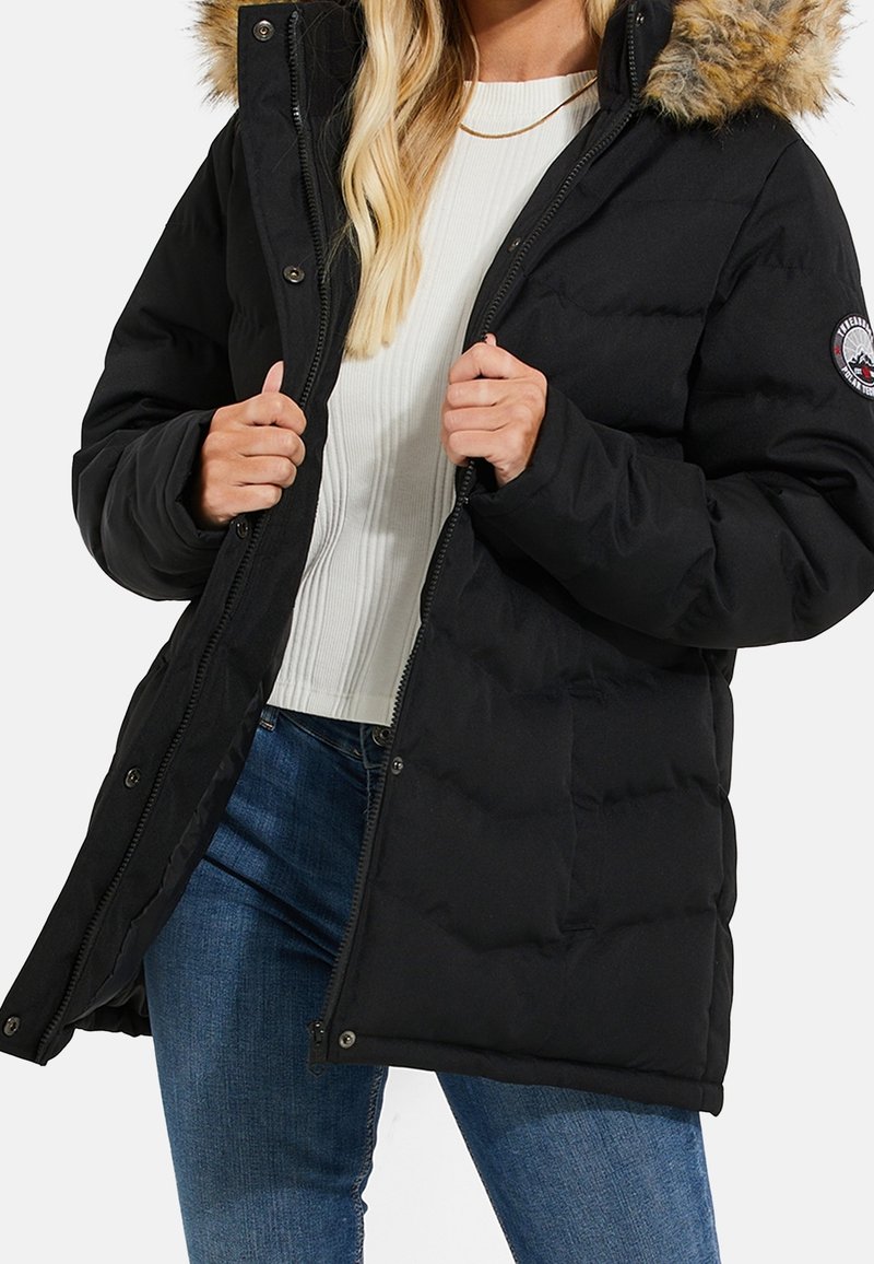 Sort pufferjakke med pelsforet hætte, quiltet design, frontknapper og lynlås samt sidelommer. Klassisk snit velegnet til vinteren.