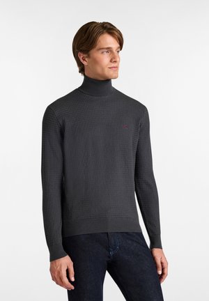 Dunkelgrauer Rollkragenpullover mit strukturiertem Strickmuster und gerippten Bündchen, mit einem kleinen roten Logo auf der linken Brust.
