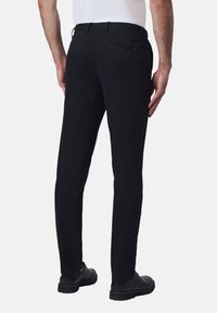 Czarne spodnie o slim fit, wykonane z gładkiego materiału. Posiadają kieszenie z tyłu oraz pasek z pętelkami.