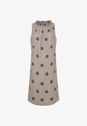 Ærmeløs beige kjole med store sorte polkaprikker og en rynket, ruflet halsudskæring, vist på en ensfarvet hvid baggrund.
