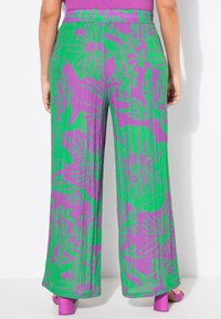 Pantaloni ampi floreali in viola e verde, caratterizzati da un vivace motivo vegetale, vita elastica e tessuto testurizzato.