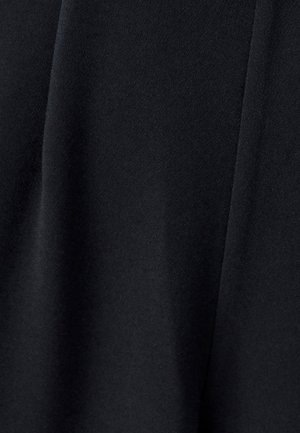 Tessuto nero con una superficie morbida e leggermente strutturata, caratterizzato da pieghe drapeate che suggeriscono un design leggero e fluido.
