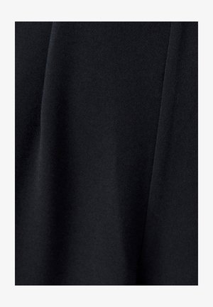 Must tume, mille pind on pehme ja kergelt tekstureeritud, sisaldab voogavad voldid, mis viitavad kergesti voolavale ja kergele disainile.