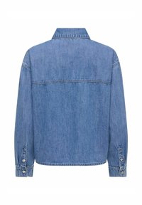 Vue de dos d'une veste en jean bleu avec manches longues, poignets boutonnés et une couture d'empiècement sur le haut du dos.