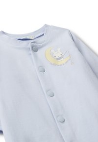 Světle modrý bavlněný overal s grafikou kresleného králíka a půlměsíce se hvězdičkou. Zapínání na tři modré knoflíky.