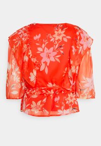 Blusa floral vermelha com tecido transparente, mangas curtas e cintura ajustada. Apresenta grandes flores cor-de-rosa e folhas delicadas por toda a parte.