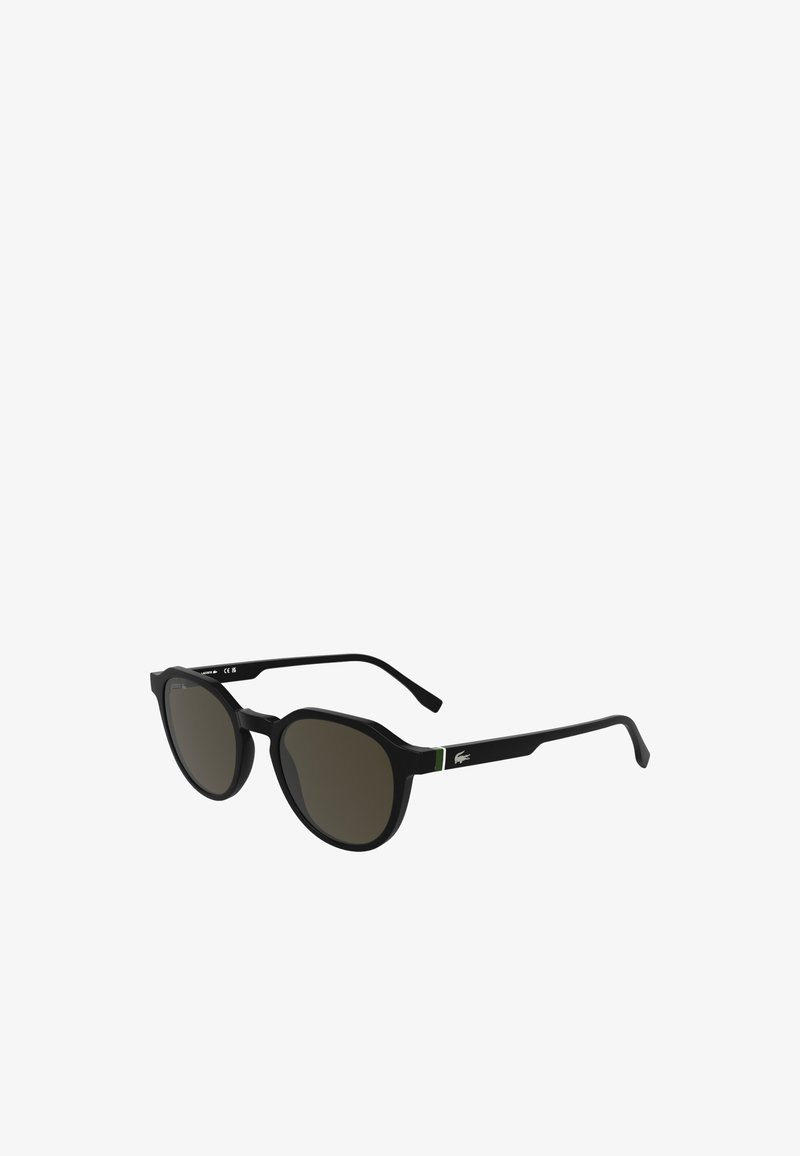 Óculos de sol pretos com lentes redondas, armação grossa e um detalhe verde de lado. Acabamento texturizado com o logótipo da marca na haste.