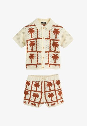 Krémová pletená súprava s krátkym rukávom na gombíky a šortky, s hnedými vzormi paliem usporiadanými do mriežkového dizajnu.