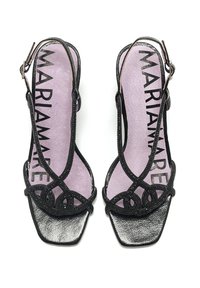 Sandalias negras con un diseño de punta cuadrada, que presentan tiras texturizadas y un patrón decorativo de lazo. La plantilla es de color púrpura claro con letras negras.
