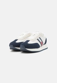 Blaue und weiße Sneakers aus Wildleder und Leder, mit drei Streifen in Rot und Marineblau, abgerundetem Zeh und strukturiertem Gummisohle.