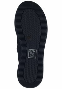 Semelle de chaussure en caoutchouc noir avec un motif ondulé, des bosses surélevées pour l'adhérence et une étiquette portant la mention "ara High Soft" au centre.