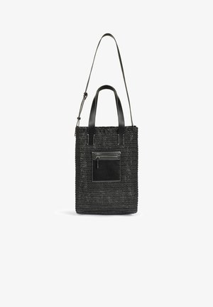 Sac fourre-tout tissé noir avec deux poignées courtes, une bandoulière longue réglable et une poche avant zippée avec surpiqûres contrastées.