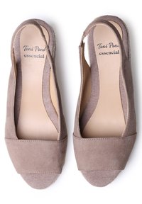 Taupe slingback shoes with a soft suede upper, open sides, and a textured fabric toe cap. Designed with a low, square heel and cushioned insole.