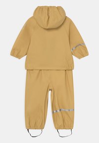 Fato de chuva amarelo, impermeável, com capuz, punhos elásticos, detalhes refletivos e ajustes por cordão nos tornozelos.