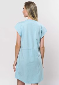 Rochie de bumbac albastru deschis cu mâneci scurte tip capac, talie strânsă și tiv ușor rotunjit, prezentând o textură simplă și netedă.