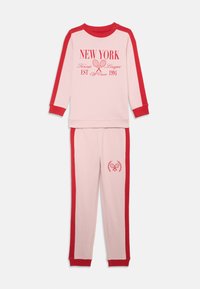 Różowy zestaw piżamowy z bawełny z czerwonymi akcentami, długimi rękawami, prążkowanymi mankietami oraz grafiką "NEW YORK Tennis League EST 1994" na górze.