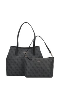Deux sacs noirs GUESS avec un motif de logo répétitif, un grand tote avec des bretelles d'épaule et une petite pochette zippée avec une sangle pour poignet.