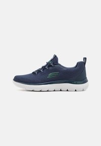 Navy mesh athletic shoe with a white lightweight sole, green accents, and a flexible design featuring a textured upper and a pull tab.