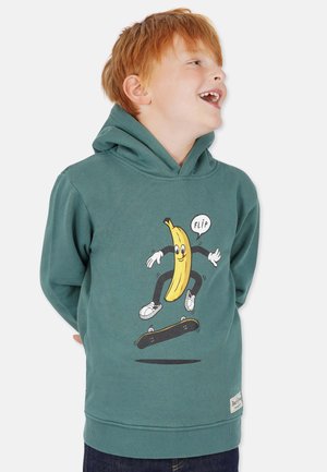 Teallin huppari, joka on valmistettu pehmeästä kankaasta, sisältää banaanigrafiikan, joka skeittaa skeittilaudalla, ja sanan "FLIP" puhekuplassa.