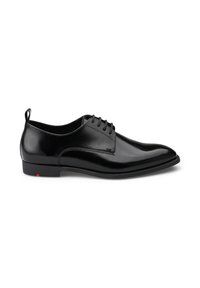 Schwarze Lederhausschuhe mit hochglänzender Oberfläche, spitzem Schuhdesign und Schnürung. Verfügt über einen kleinen roten Akzent an der Ferse.