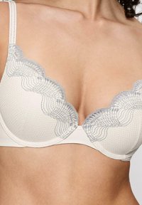 Biały stanik z koronkowymi krawędziami w jasnoszarym kolorze, z wyprofilowanymi, teksturowanymi miseczkami, regulowanymi ramiączkami oraz gładkim detalem pod biustem.