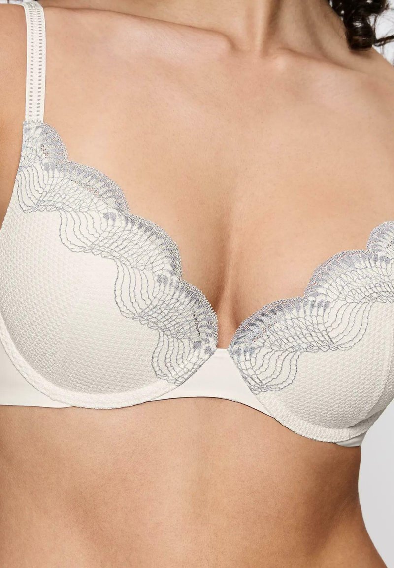 Biały stanik z koronkowymi krawędziami w jasnoszarym kolorze, z wyprofilowanymi, teksturowanymi miseczkami, regulowanymi ramiączkami oraz gładkim detalem pod biustem.