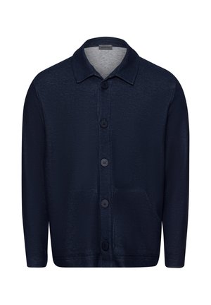 Tummansininen napitettava neulejakku, joka on valmistettu teksturoidusta kankaasta. Siinä on kaulus, etutaskut ja kuusi nappia keskellä.