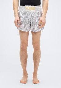 Ανοιχτό γκρι αθλητικό σορτς με απαλό ελαστικό ζωνάρι μέσης που φέρει τη λέξη «VENUM» σε χρυσό χρώμα. Το ύφασμα έχει ένα διακριτικό αφηρημένο σχέδιο.