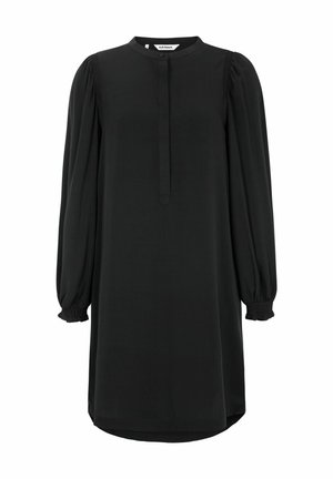 Melnas kleitas, kas izgatavota no gludas auduma, iezīmē apaļu kakla izgriezumu, garām pūkainām piedurknēm ar savilktiem aprocēm un pogu aizdari priekšpusē.