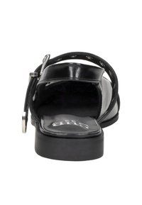 Zwarte leren sandalen met een open achterkant, een platte zool, decoratieve zilveren hardware en uitsnijdingen op de band. Gladde textuur.