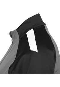 Zwarte en grijze jas met rits, voorzien van een hoge kraag, gestructureerde stof en een opvallende witte accent op de achterkant nabij de halslijn.