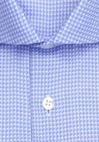 Blau-weiß kariertes Hahnentrittmuster-Hemd mit spitzem Kragen und einem sichtbaren weißen Knopf vorne geschlossen.