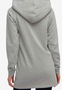 Sudadera gris claro hecha de una tela suave, con una gran capucha, mangas largas y una parte trasera más larga para mayor cobertura.