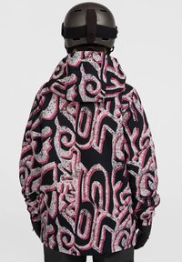 Zwarte jas met witte en roze abstracte patronen, verstelbare capuchon en elastische manchetten, ontworpen voor buitenactiviteiten.