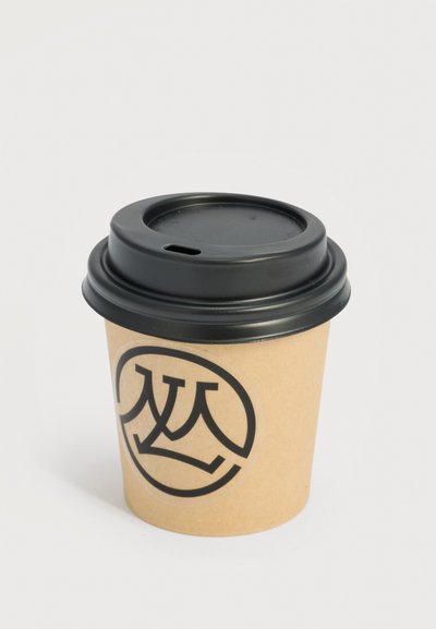 Μια πλαστική προσωρινή καφέ χάρτινη κούπα καφέ με μαύρο καπάκι και ένα μαύρο κυκλικό λογότυπο που απεικονίζει στυλιζαρισμένα επικαλυπτόμενα γράμματα.