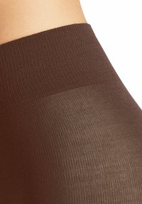 Collants opaques marron avec une texture lisse, dotés d'une large ceinture et d'un design sans coutures. Le matériau semble extensible et moulant.