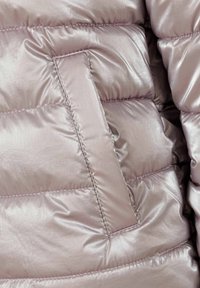 Giubbotto imbottito rosa chiaro con esterno lucido e testurizzato, dotato di un dettaglio con tasca rettangolare, cucito con un motivo a rombi.
