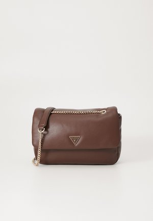 Brown leather shoulder bag with gold chain strap and triangular Guess USA logo on front flap against white background.