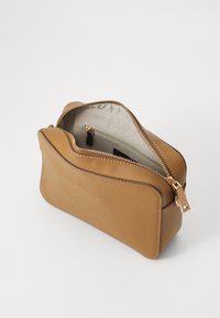 Borsa cosmetica in pelle abbronzata e testurizzata con design impresso, zip dorata e interno foderato in tessuto con tasca con zip.
