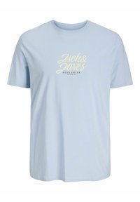 Lys blå bomulds t-shirt med korte ærmer, rund hals og hvidt logo "Jack & Jones" med "WORLDWIDE STUDIO" i mørkerød nedenunder.