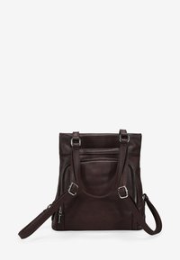 Bolso de cuero en marrón oscuro con dos asas y correa de hombro ajustable. Cuenta con un bolsillo con cremallera en la parte frontal y una superficie texturizada.