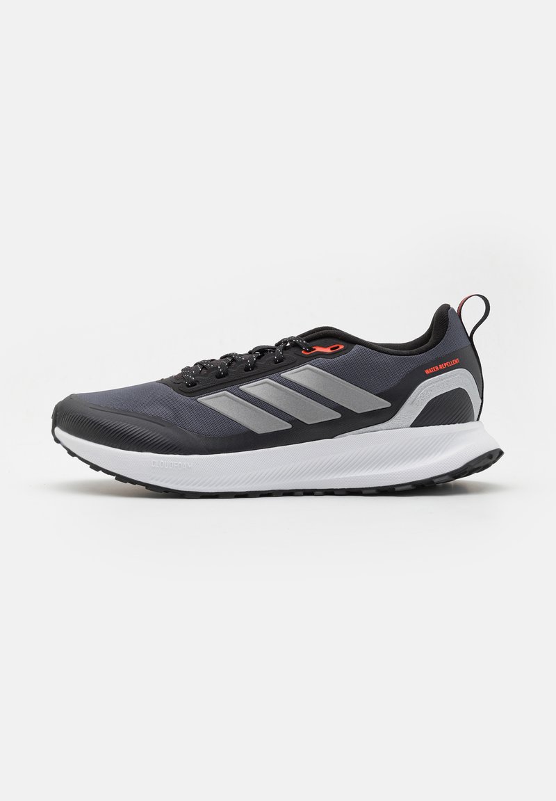 Μαύρο και γκρι παπούτσι δρόμου Adidas με λευκή σόλα, σχέδιο με κορδόνια, τρεις πλευρικές ρίγες και αδιάβροχη ετικέτα στη φτέρνα.