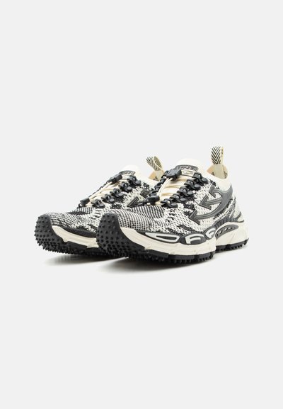 Ζευγάρι ασπρόμαυρα πλεκτά αθλητικά παπούτσια με υφασμένες σόλες, λογότυπο με βέλος στα πλάγια και θηλιές στο πίσω μέρος.