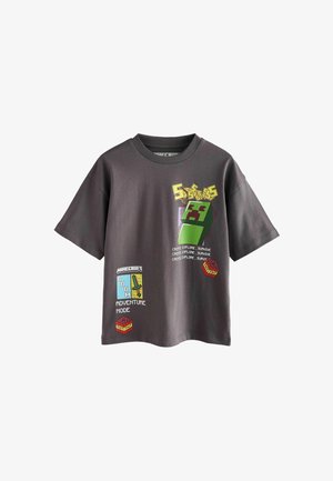 Šedé bavlnené tričko s grafikou na tému Minecraft, vrátane zeleného charakteru, blokov a textu v jasných farbách. Krátke rukávy a okrúhly výstrih.