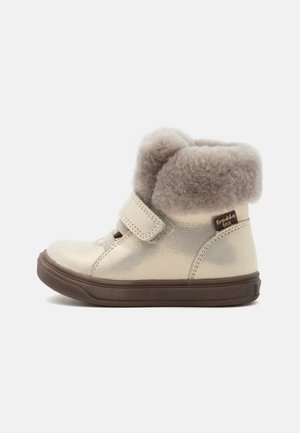 Børns beige vinterstøvle med brun sål, velcrobånd og en blød pelsforing rundt om anklen, mærket "froddo tex."
